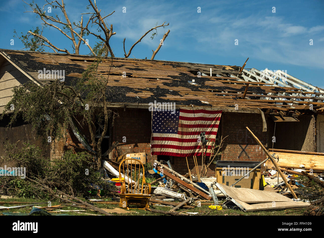 Resident in Moore, Okla. displays an American Flag on their home May 22, 2013. On Monday a EF-5 tornado, with winds reaching at least 200 mph, traveled for 20 miles, leaving a two-mile-wide path of destruction, leveling homes, crushing vehicles, and killing more than 20 people. More than 115 Oklahoma National Guard have been activated to assist in the rescue and relief efforts. Stock Photo