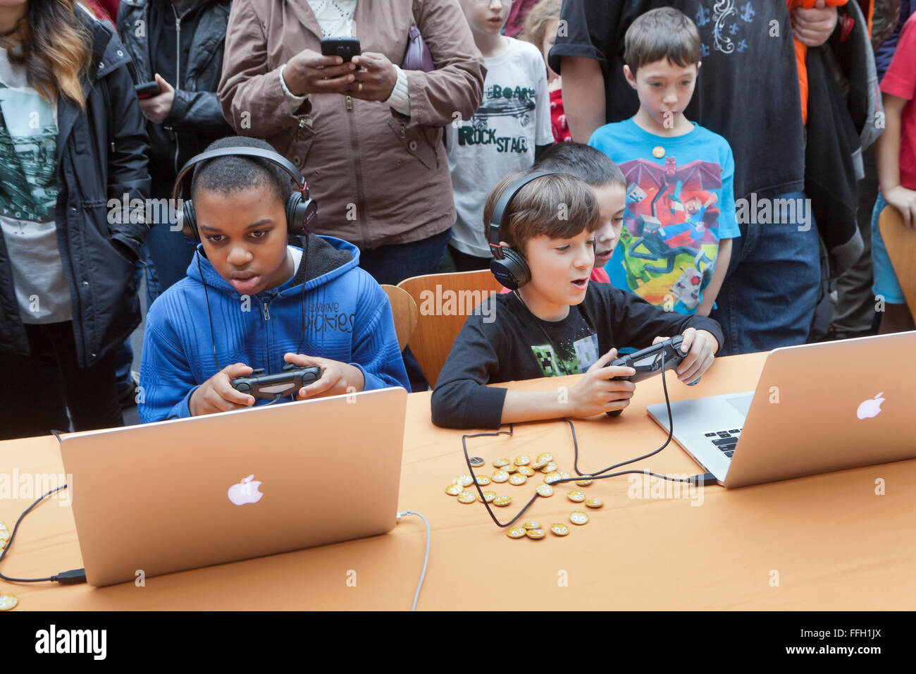Children playing video games on Apple Powerbook laptop computers - USA Stock Photo