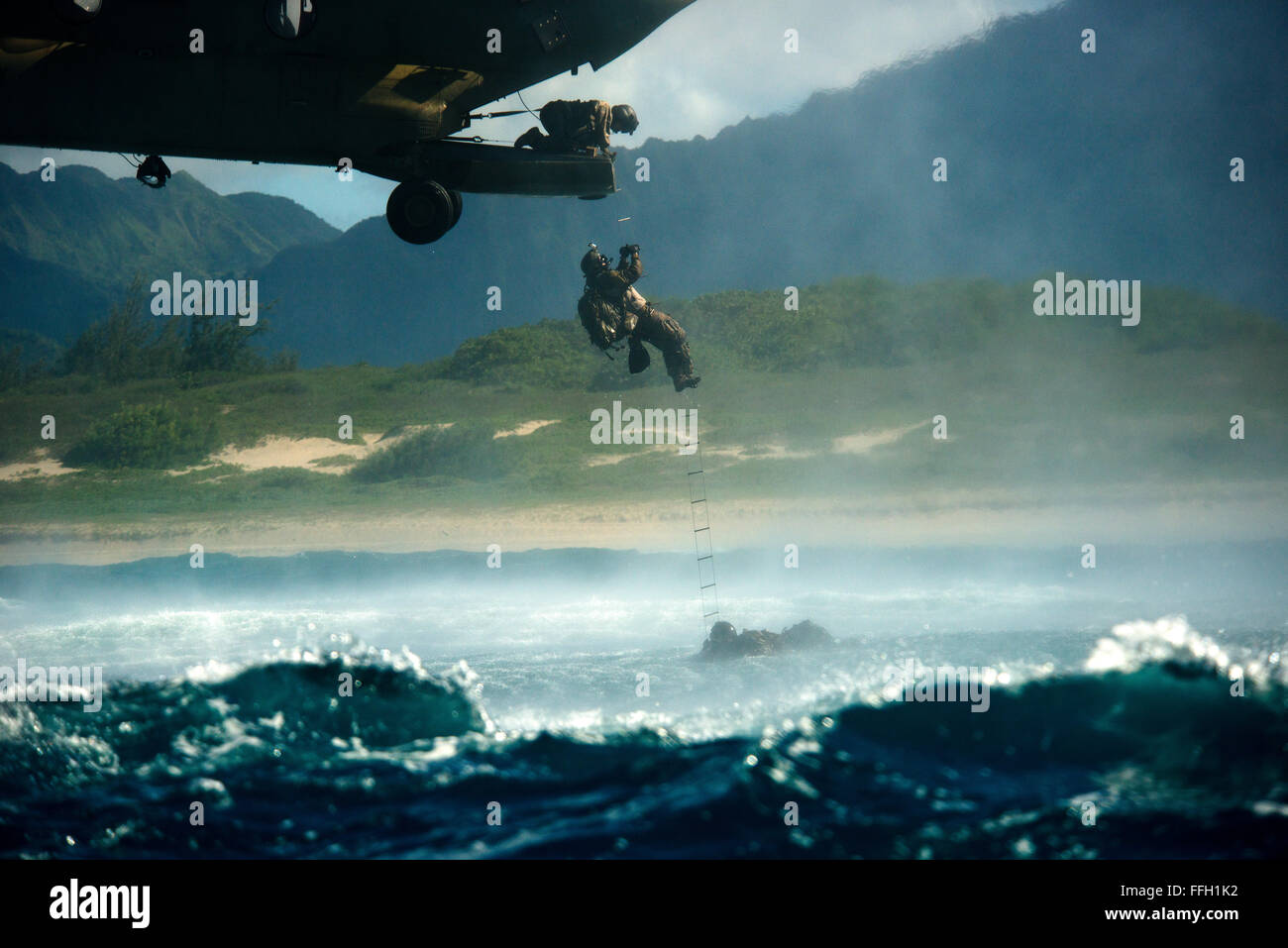 An Airman from the 22nd Special Tactics Squadron climbs a ladder into a CH-47 Chinook hovering above the ocean. University of Pittsburgh researchers monitor vital signs of the operators as they perform the operation. Stock Photo