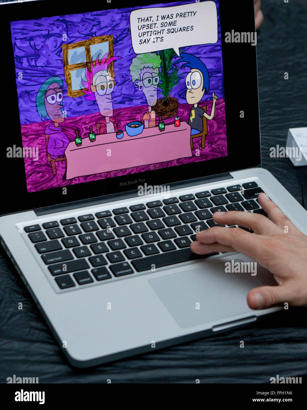 Man viewing computer animation on MacBook Pro laptop - USA Stock Photo