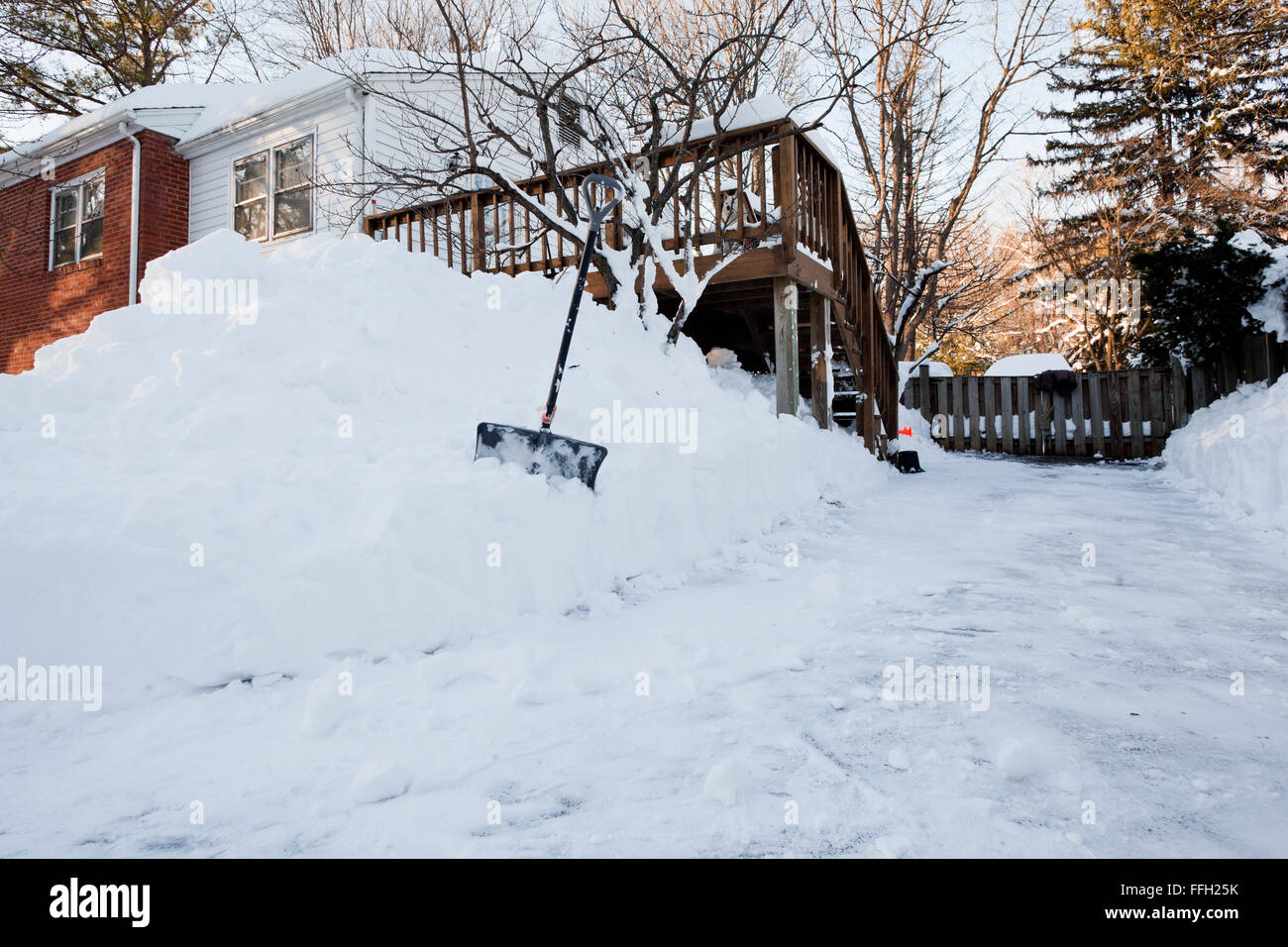 Large snow pile shoveled from house driveway Virginia USA Stock Photo