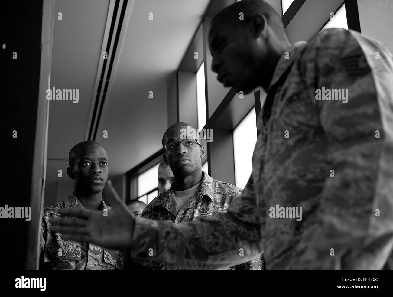 323rd Training Squadron, military training instructor, Tech. Sgt. Chananyah Stuart, explains the dorm cleaning procedures to Airmen, Sidney Player and Justin Parker at Joint Base San Antonio-Lackland, Texas. Perfection is demanded of the trainees during the eight weeks of training though it is rarely achieved. Stock Photo