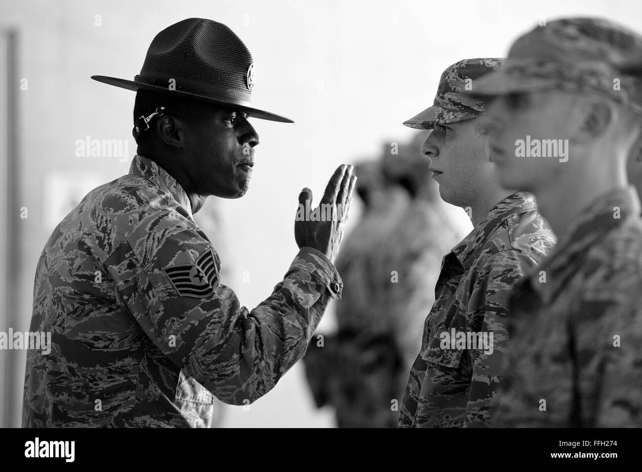 323rd Training Squadron, military training instructor, Tech. Sgt. Chananyah Stuart, uses a 'knife hand' while correcting a trainee during the first week of basic military training at Joint Base San Antonio-Lackland, Texas. Stock Photo