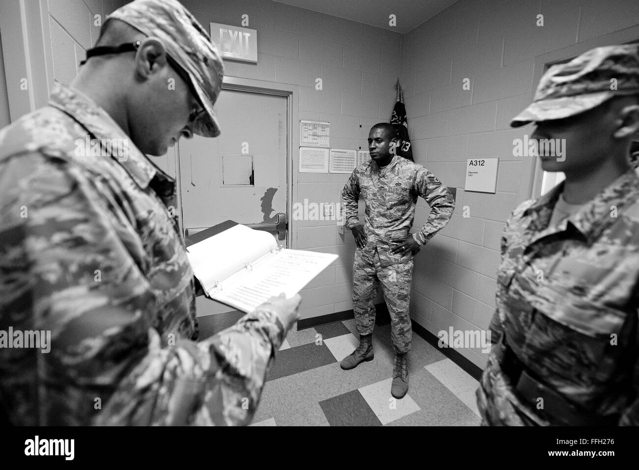 323rd Training Squadron, military training instructor, Tech. Sgt. Chananyah Stuart, watches for any mistakes as trainees perform dorm guard procedures for the first time at Joint Base San Antonio-Lackland, Texas. Each student is responsible for following very specific procedures while performing the duty. Stock Photo