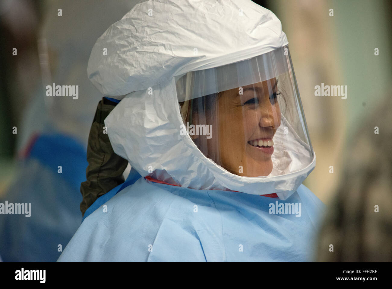 Capt. Tanya Tsosie watches teammates don their personal protective equipment during a week-long training program at the San Antonio Military Medical Center in San Antonio. Tsosie is one of 30 military members assigned to an Ebola medical support team designed to provide provide short-notice assistance to civilian medical professionals in the United States. Stock Photo