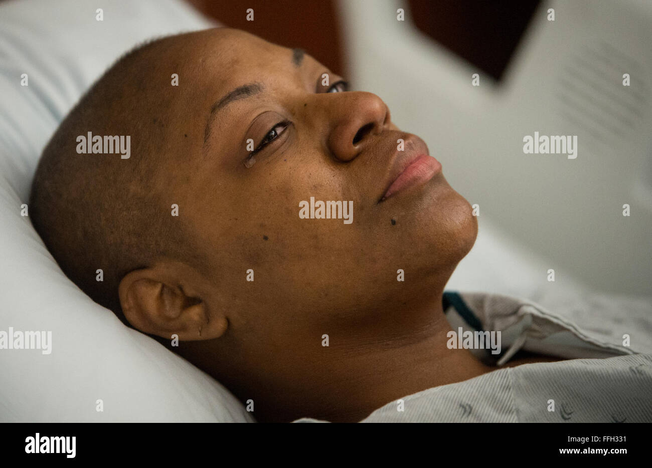 A tear begins to fall down the face of Staff Sgt. Chantel Thibeaux, Joint Base-Fort Sam Houston, Texas, dental assistant instructor, as she receives treatment from a nurse after surgery at the San Antonio Medical Center. With her husband and mother standing by her bed side saying encouraging words, Thibeaux slowly regains energy throughout the night. Stock Photo