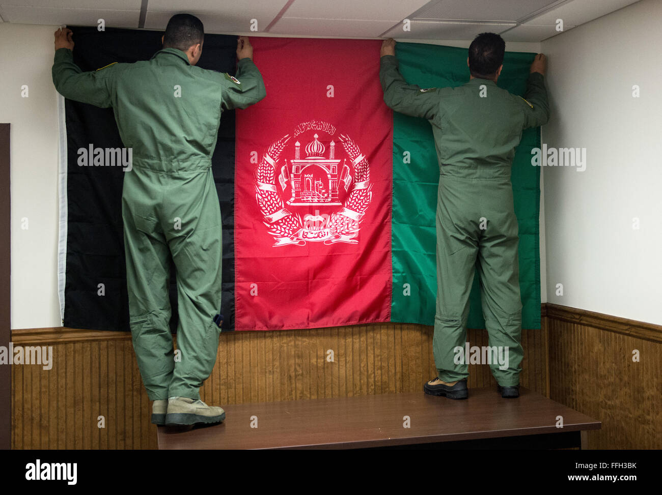 Afghan student pilots hang an Afghan flag on the wall of their training room at the 81st Fighter Squadron, Moody Air Force Base, Georgia. Moody was selected to host the training because of the available airspace, airfield and suitable facilities. Stock Photo