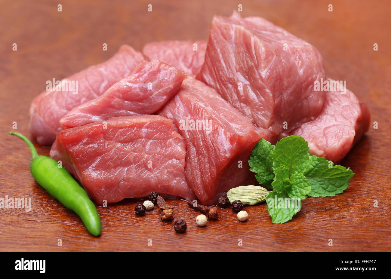Raw beef with spices on wooden surface Stock Photo