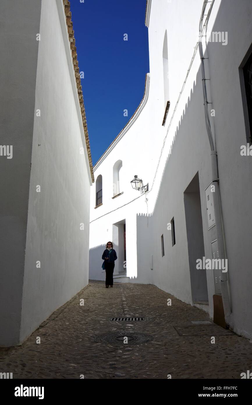 Tourist walks down a street with white walls in Spain Stock Photo