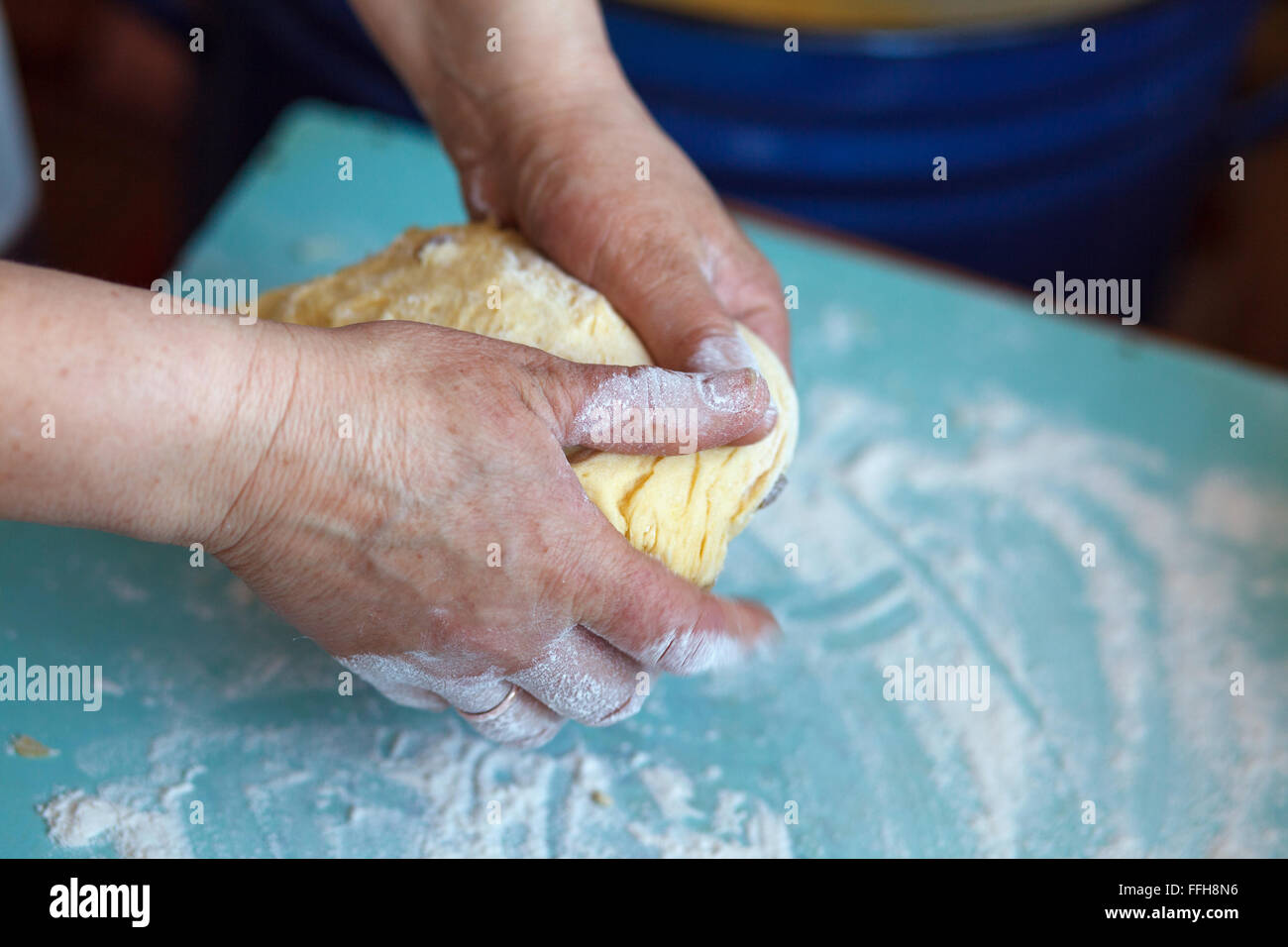 Woman's hands knead dough on a table Stock Photo - Alamy