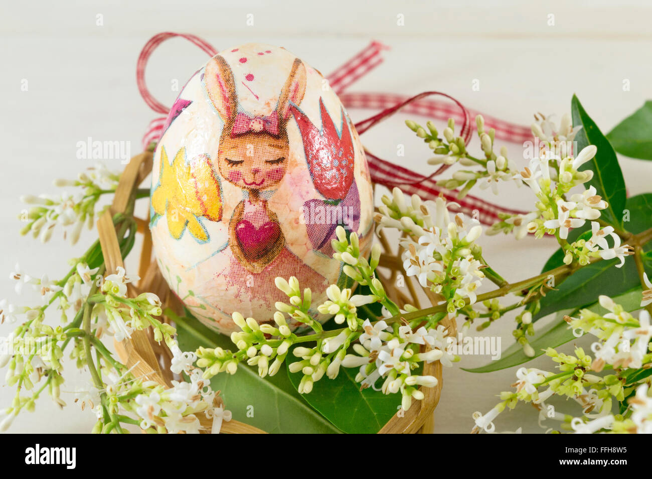 Hand painted and decoupage decorated Easter egg among elder flowers Stock Photo