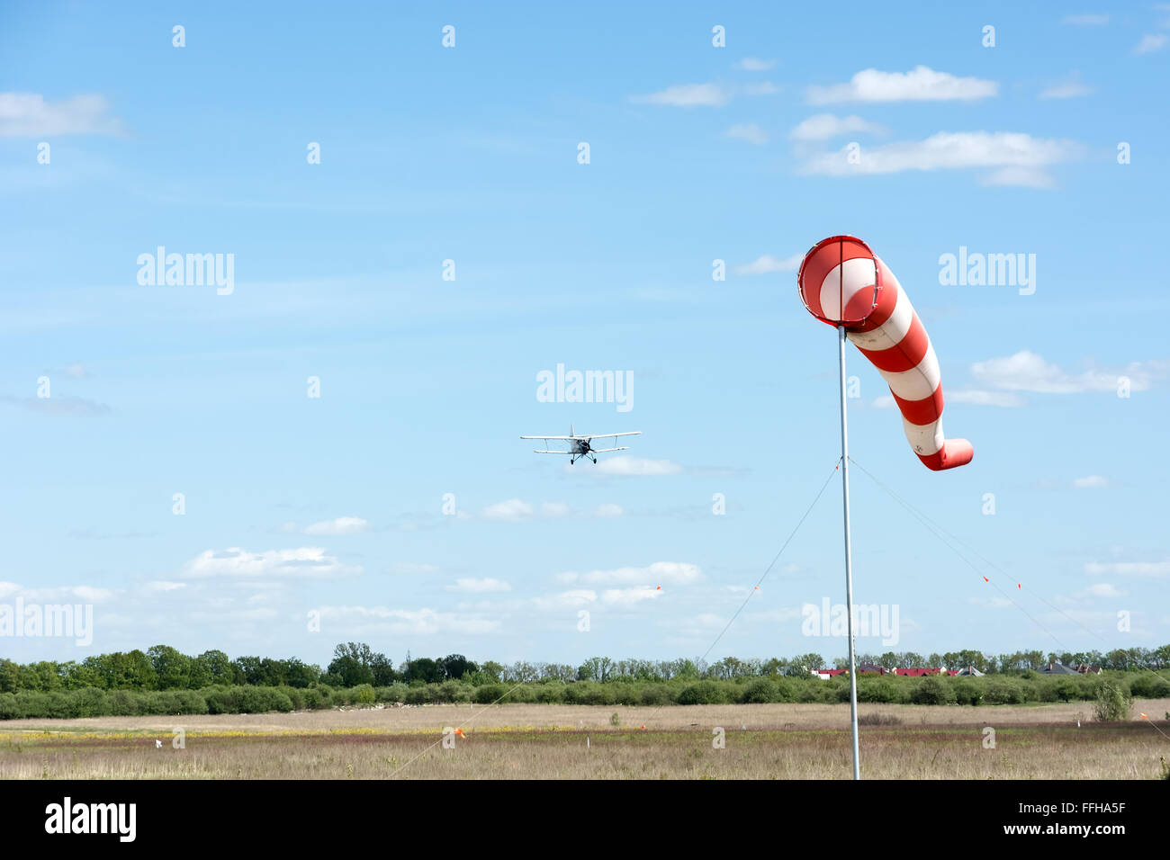 Windsock and going to land the plane on a background of blue sky. Stock Photo