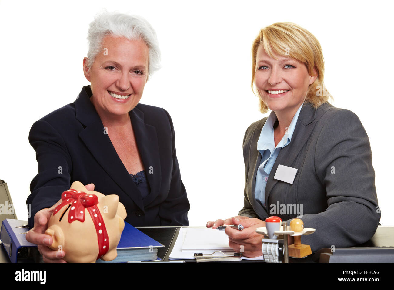 Senior woman with piggy bank and financial adviser in office Stock ...