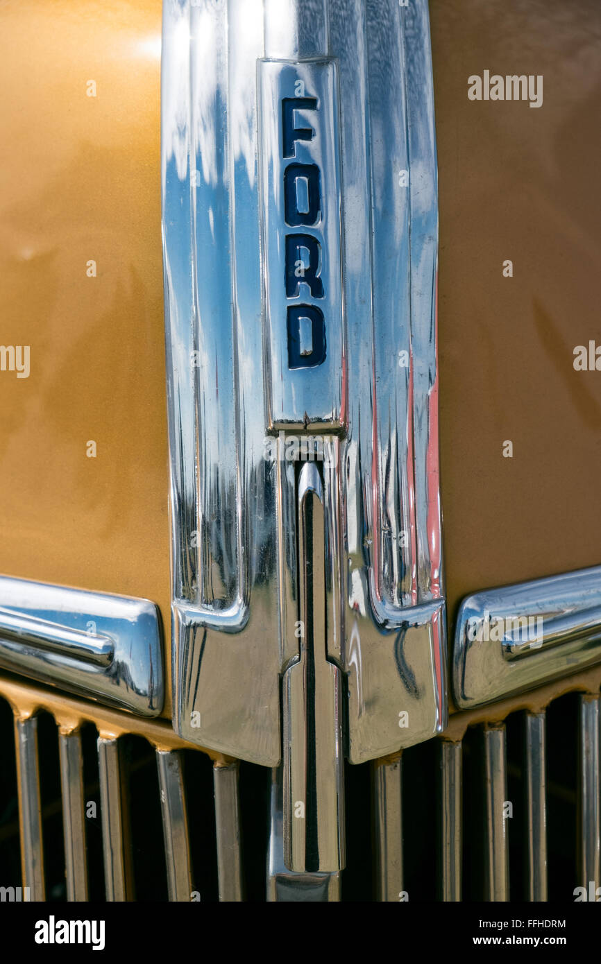 A closeup of the chrome hood detail of a gold American retro, historic Ford motor car Stock Photo