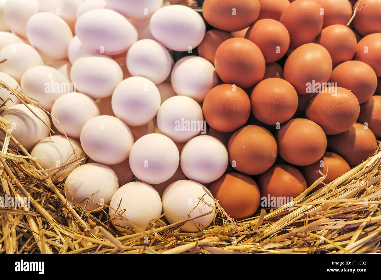 Mountain of brown and white eggs in straw Stock Photo - Alamy