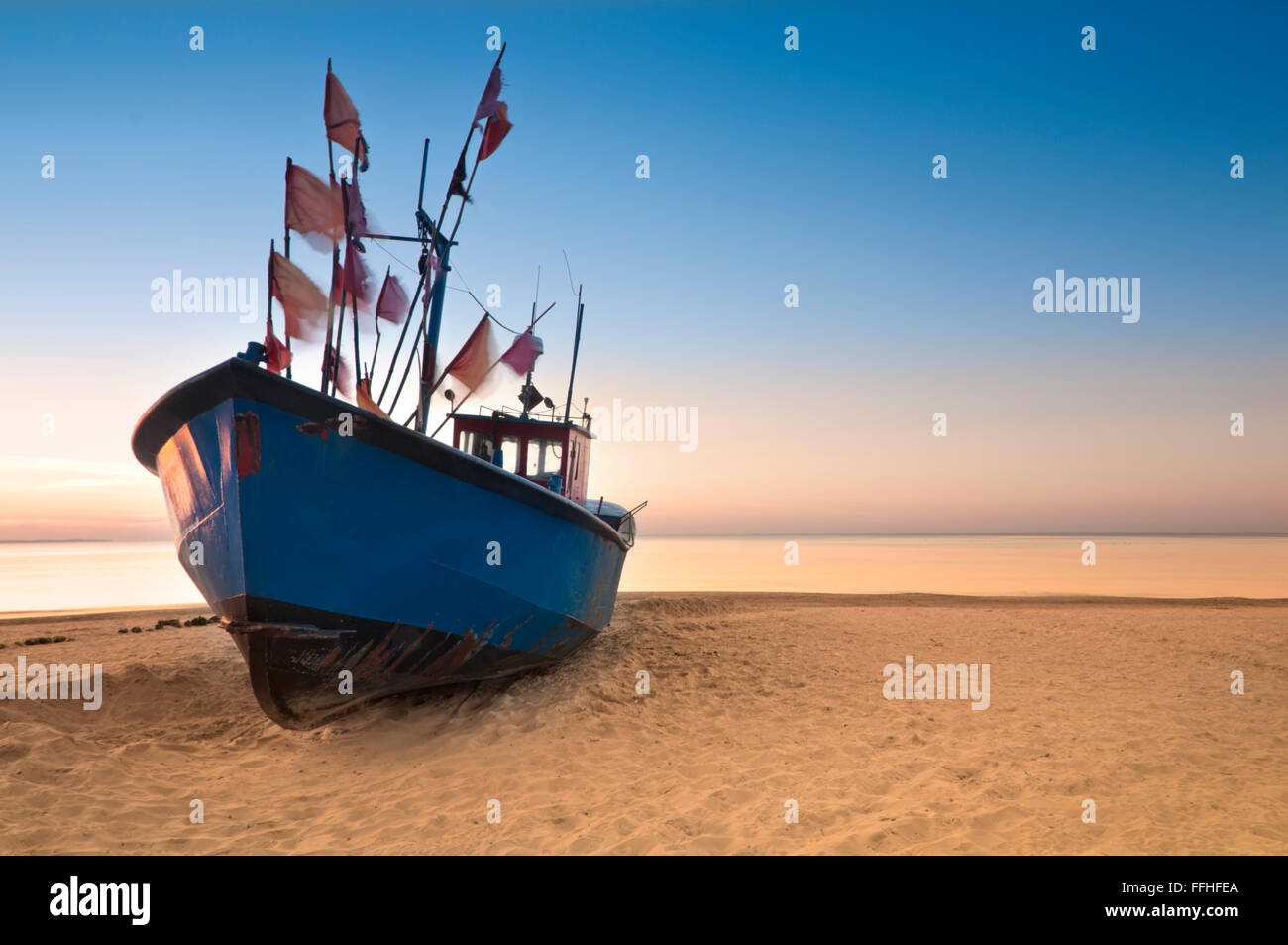 Fishing boat on the sandy beach of Baltic Sea coast wallpaper background Stock Photo