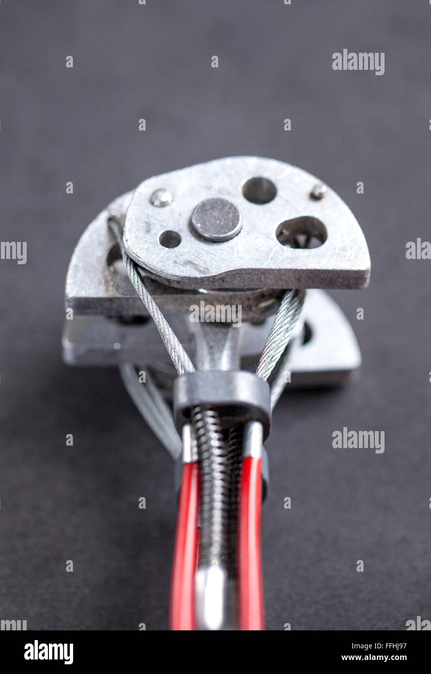Close up view of a climbing friend gear, also known as spring-loaded camming device (SLCD), on dark background. Stock Photo