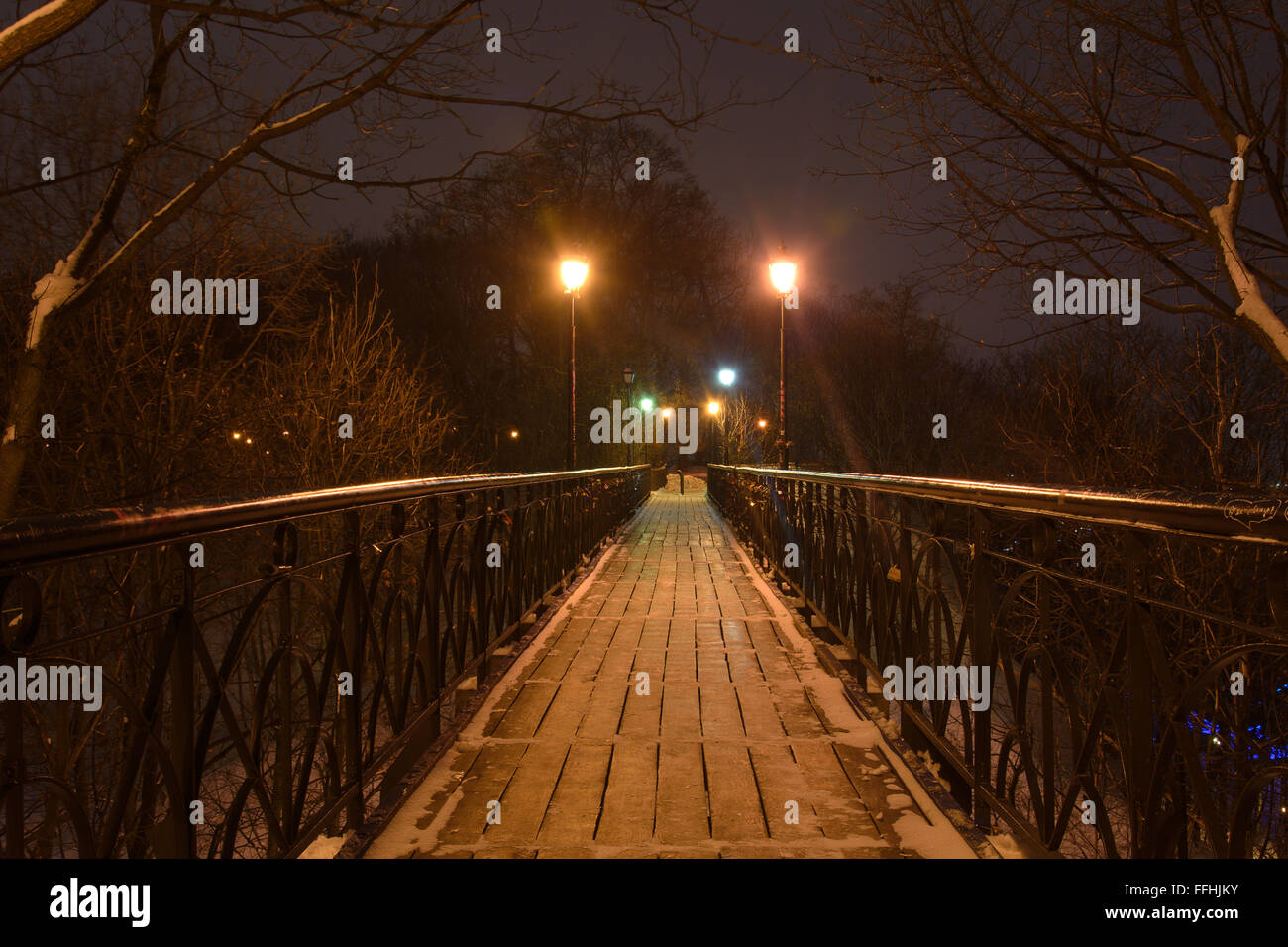 Pedestrian bridge in a city park in the winter evening Stock Photo - Alamy