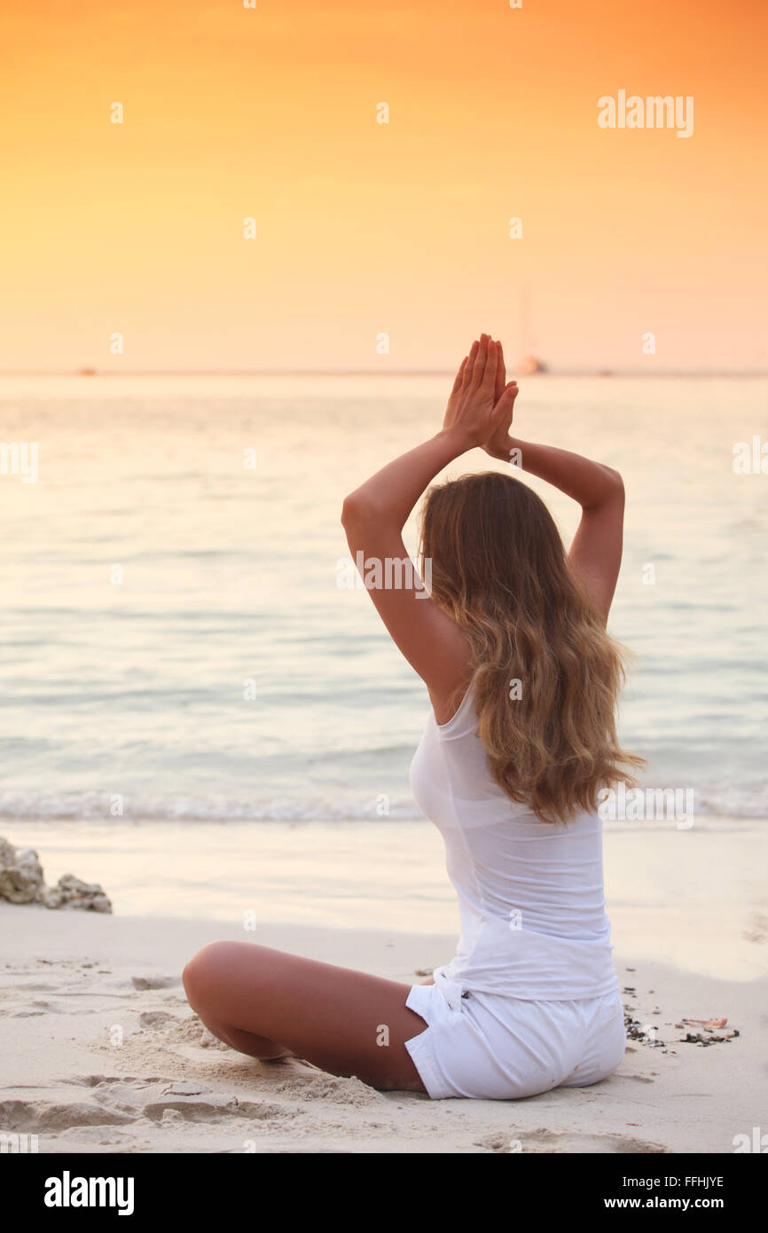 Woman in lotus yoga pose at sunset on the beach Stock Photo - Alamy