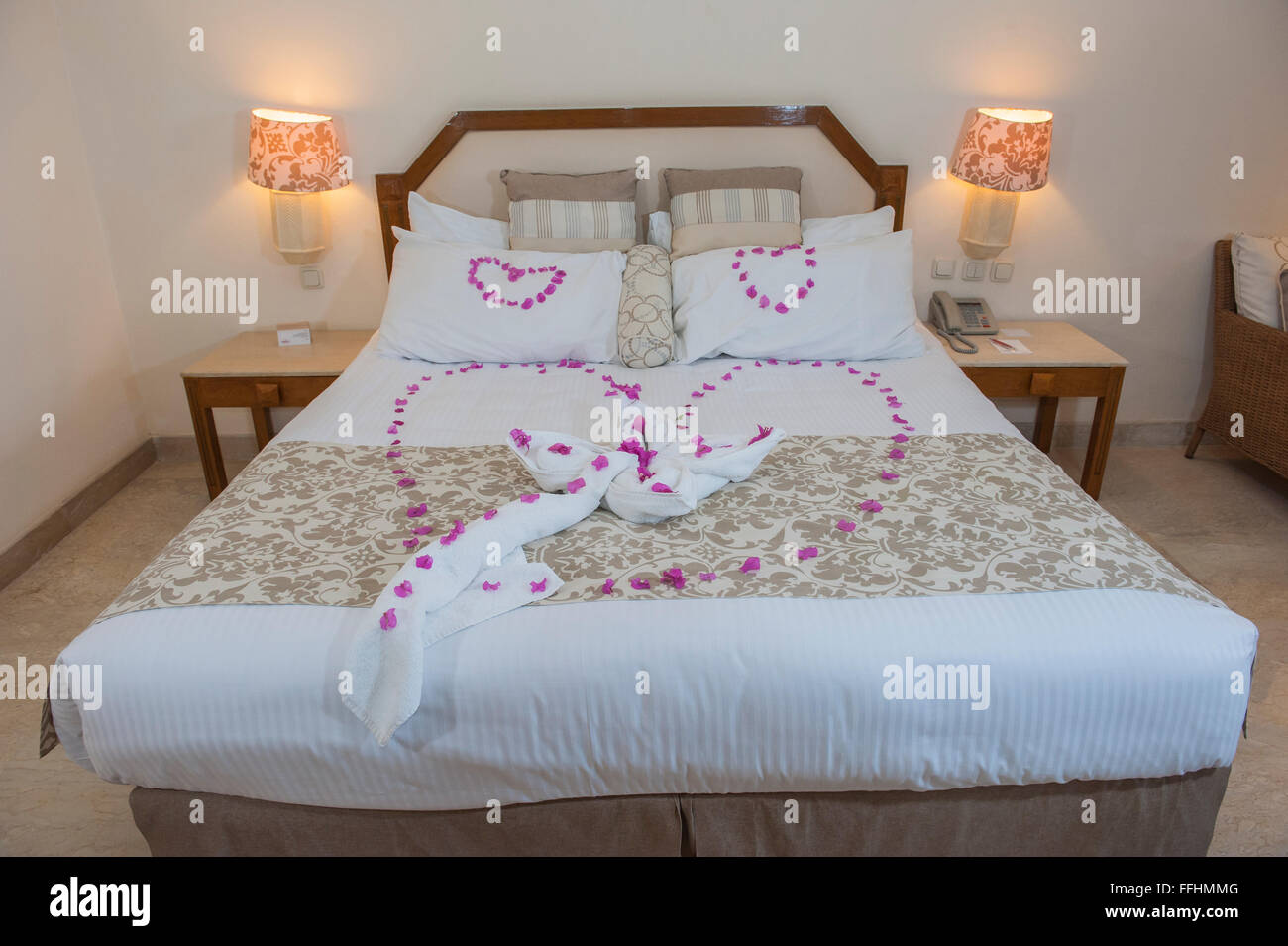 Double bed with love heart from rose petals in bridal suite of a hotel