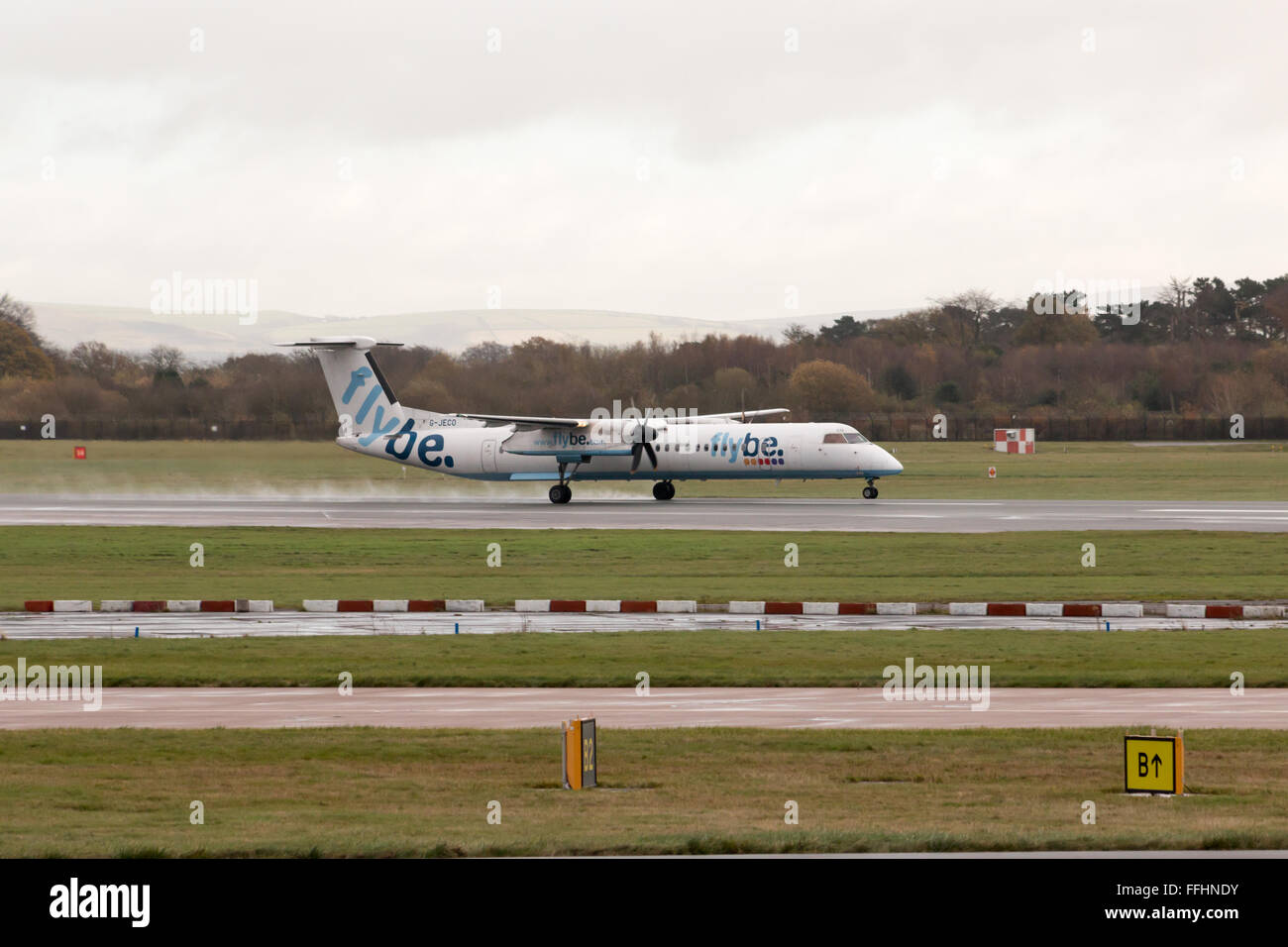 Flybe Bombardier Dash 8 Q400 regional turboprop passenger plane (G-JECO) taking off from Manchester International Airport runway Stock Photo