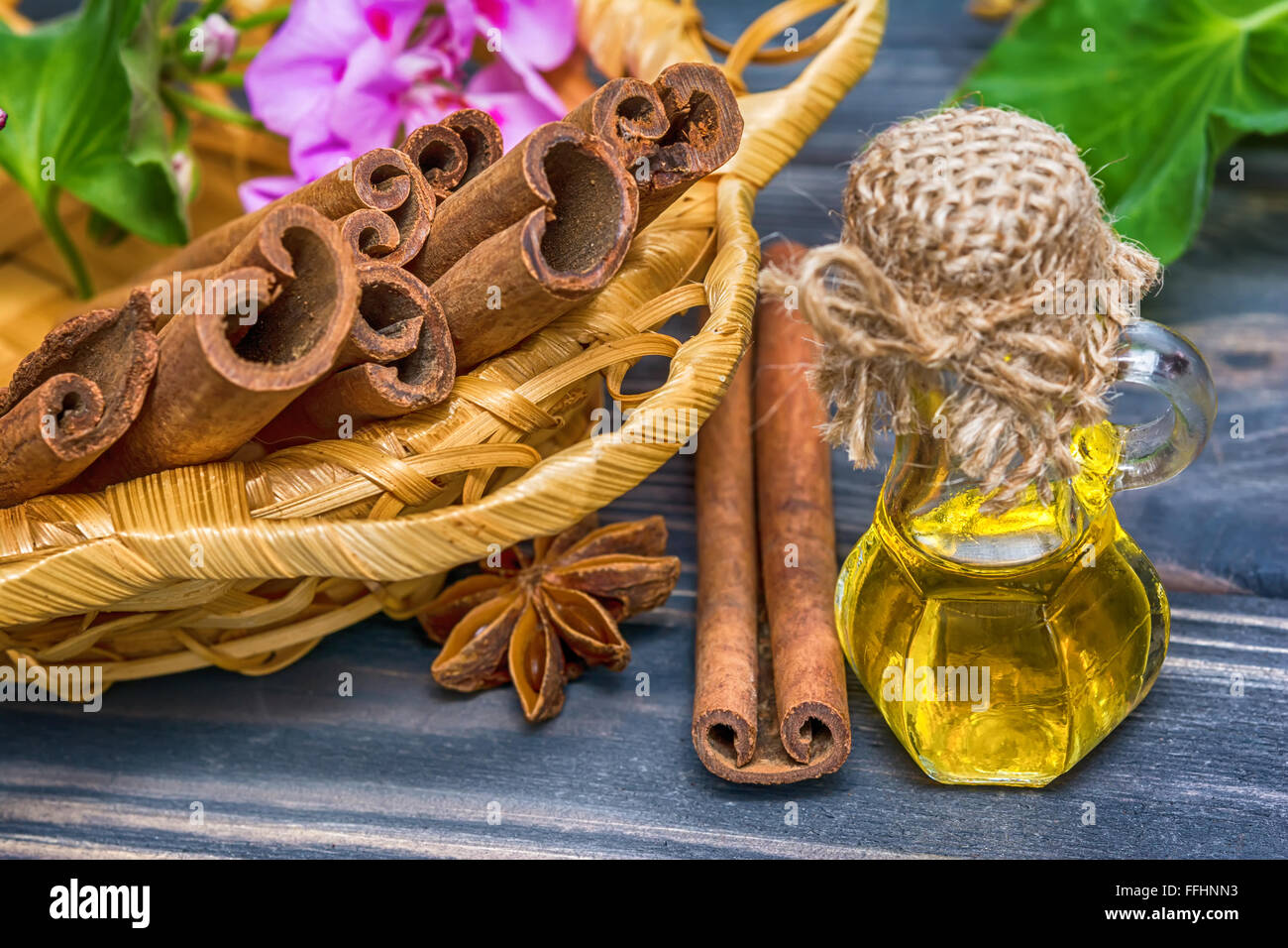 Essential cinnamon oil in bottle and cinnamon cticks Stock Photo