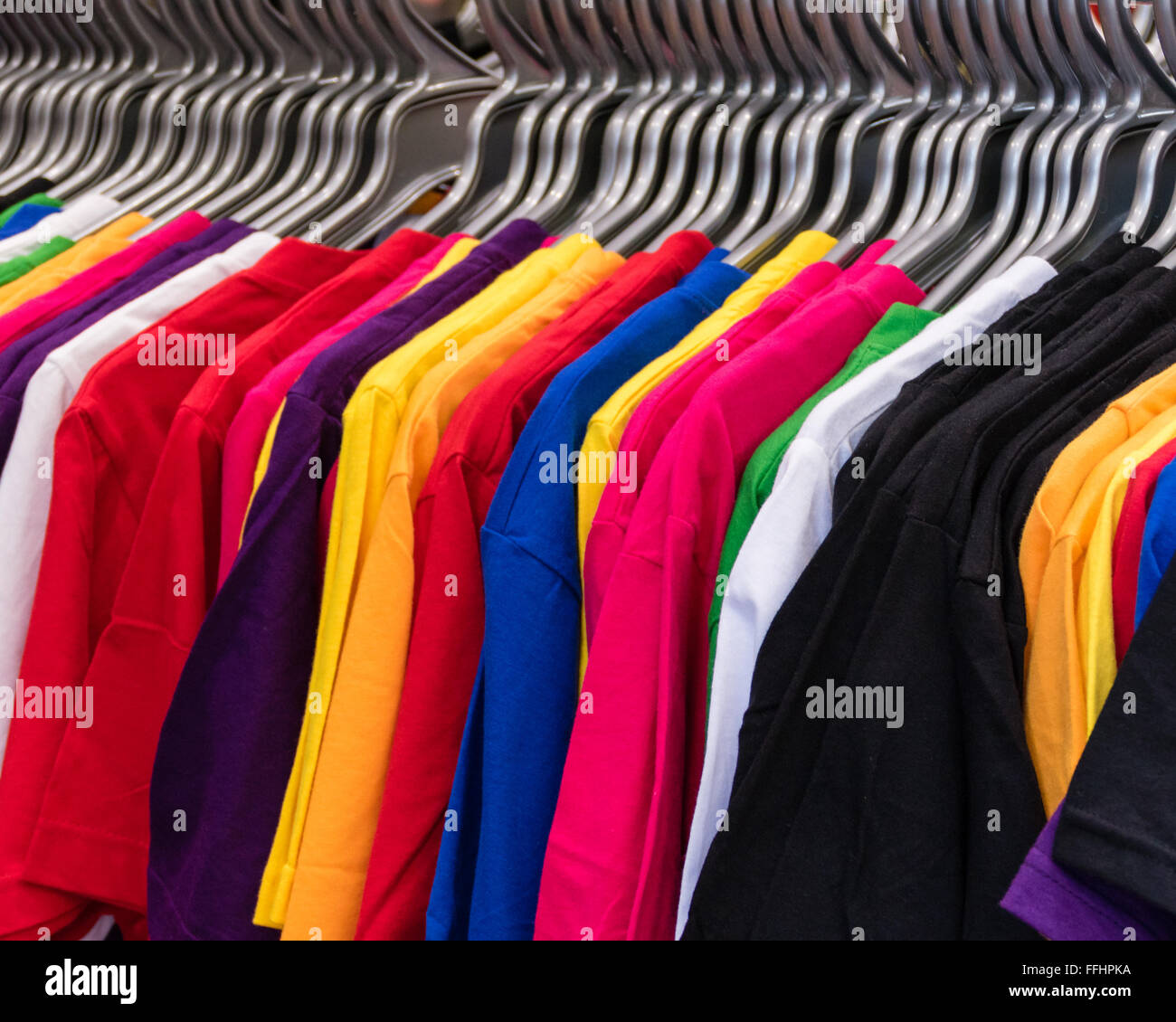 Colorful t-shirts on hangers on rack Stock Photo - Alamy