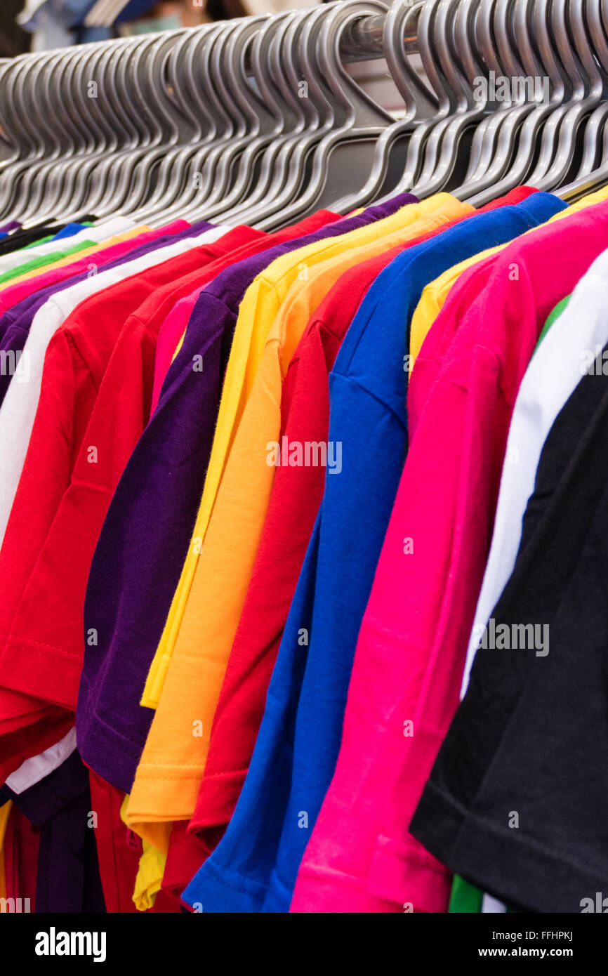 Colorful t-shirts on hangers on rack Stock Photo