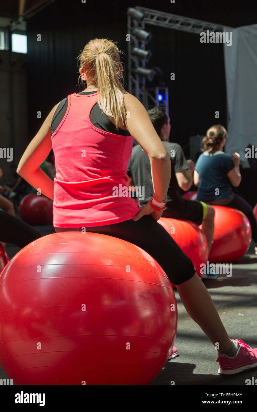 Blonde Young Girl doing Fitness Activity Sitting on Big Red Ball