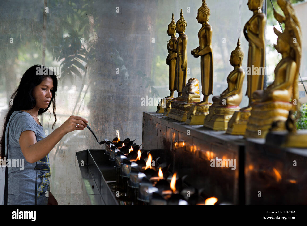 Woman praying in Wat Patum Wanaram Tample. Bangkok. Wat Pathum Wanaram is a Buddhist temple in Bangkok, Thailand. It is located Stock Photo