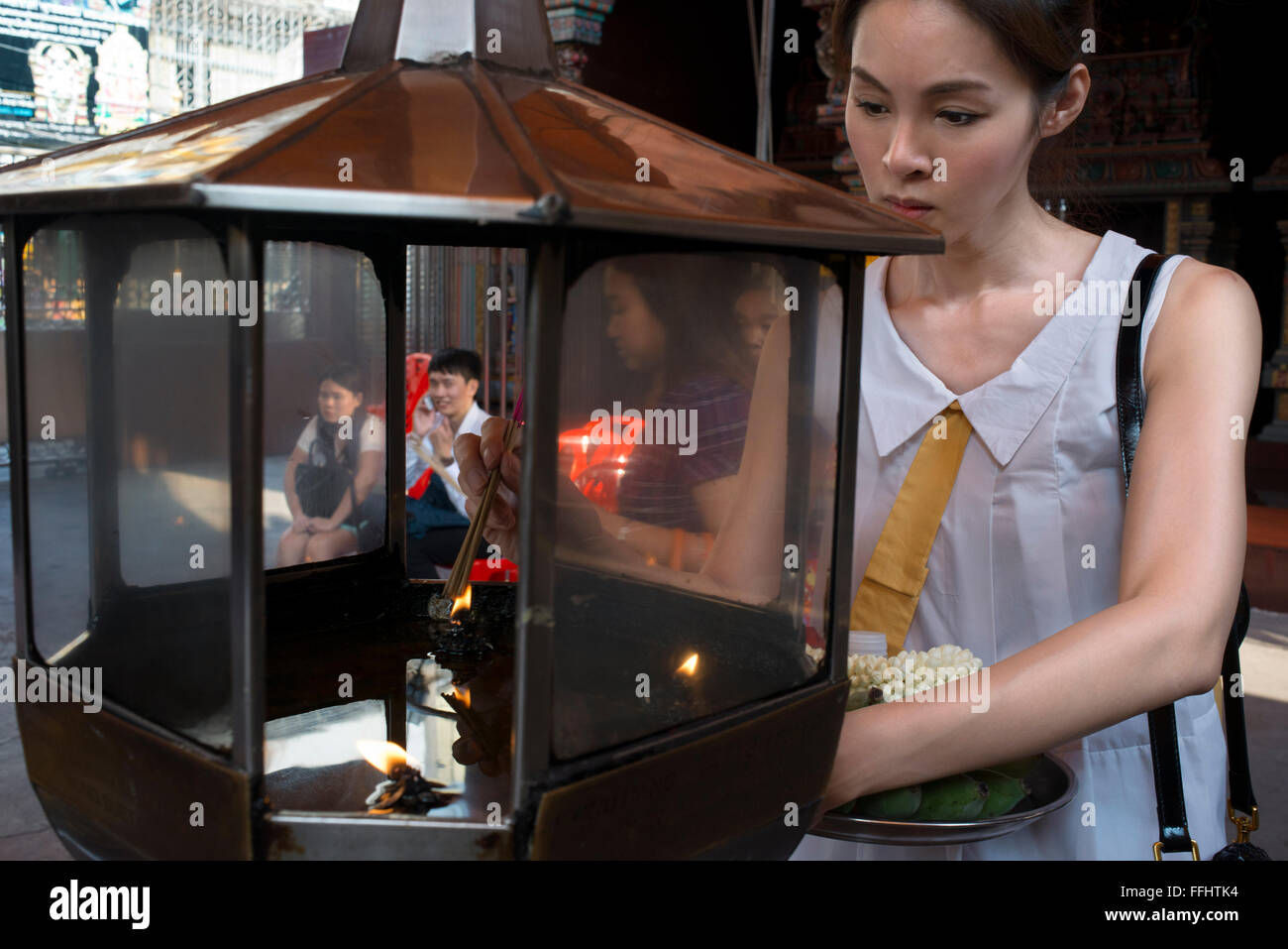 Woman praying in Erawan Shrine. Bangkok. Thailand. Erawan Shrine in Bangkok is Brahman, not strictly Buddhist. And yet, this fam Stock Photo