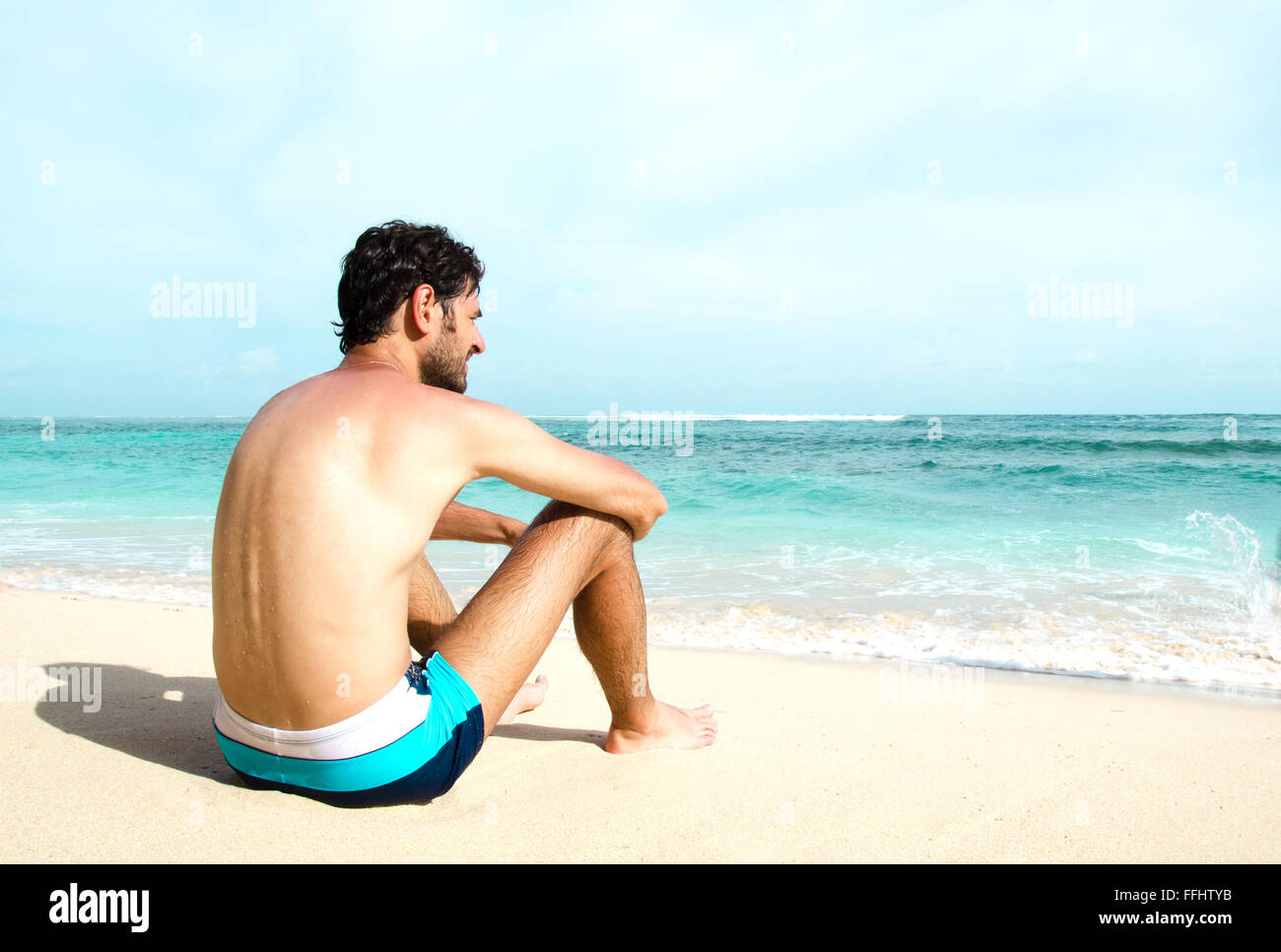 The man enjoys the view of the ocean on a sunny beach. Stock image Stock Photo