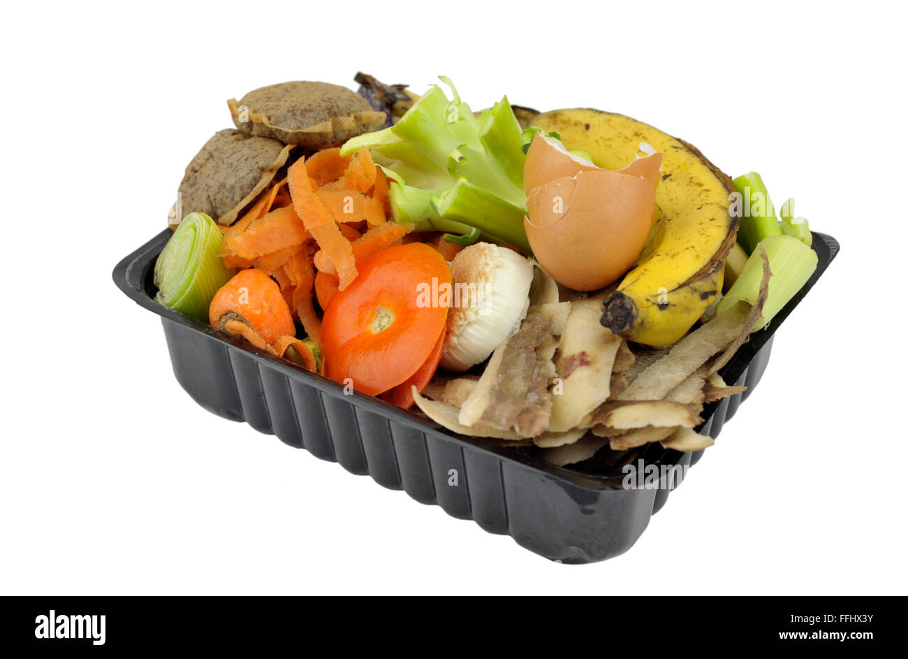 Vegetable, fruit household kitchen food waste, collected in re-used packaging, for home composting or adding to worm bin. Stock Photo