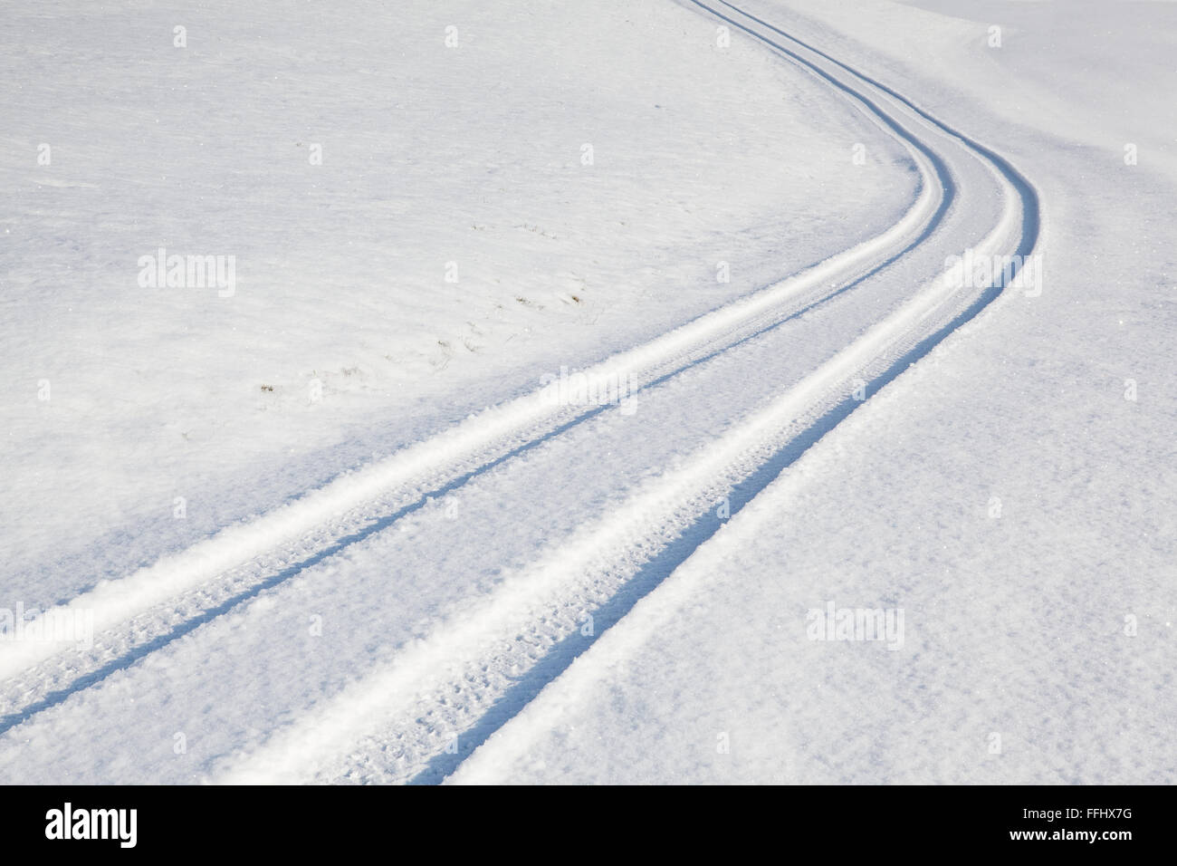 Car tire track on a empty winter road Stock Photo