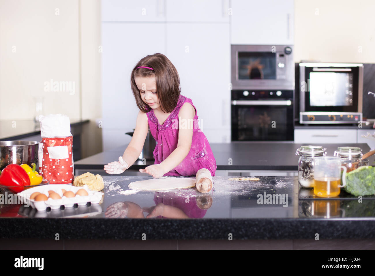 Girl cooks food in the kitchen at home. Little cook. stock image. Stock Photo