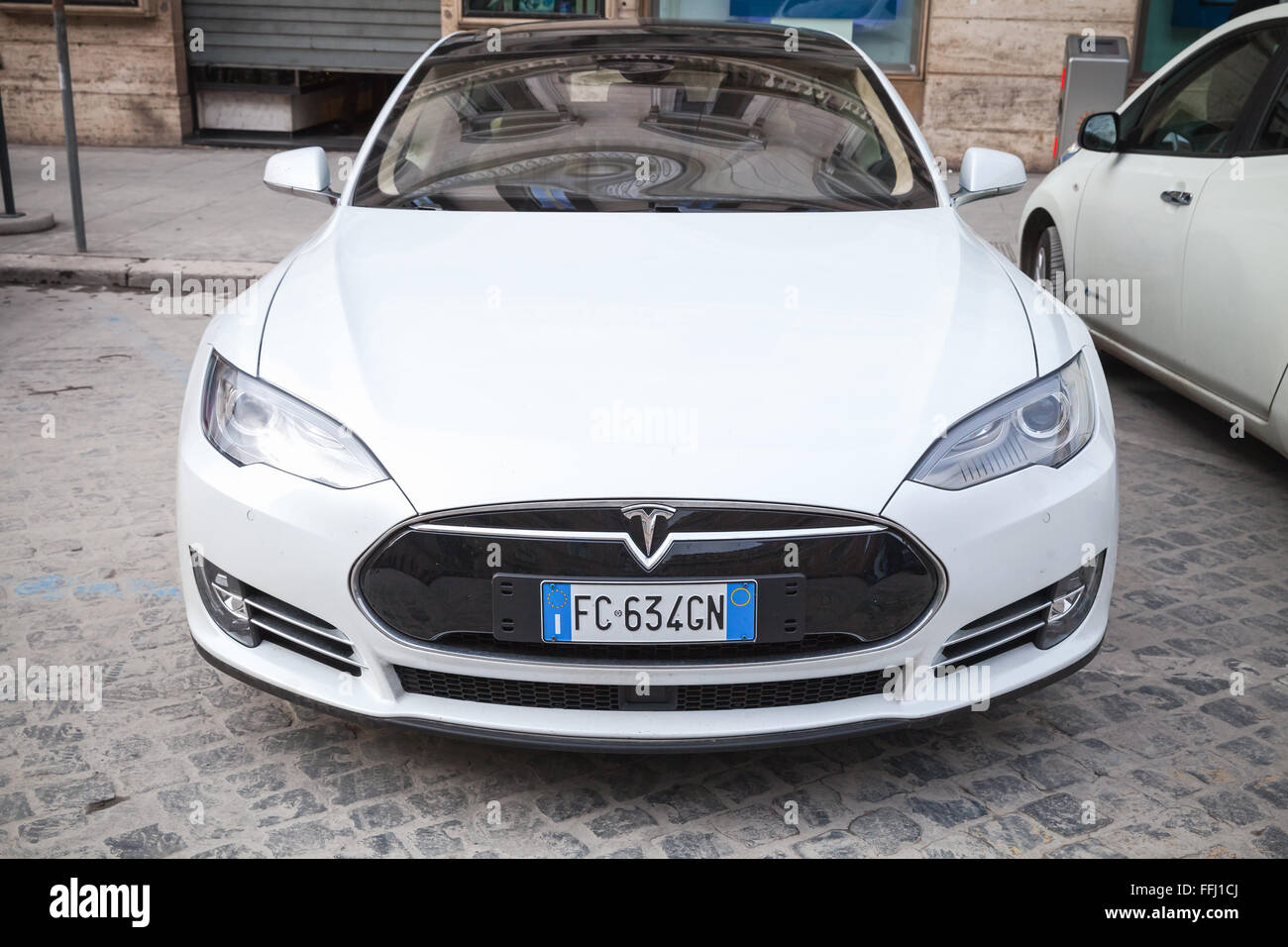 Rome, Italy - February 13, 2016 : White Tesla model S car parked on urban roadside in Rome, front view, close-up photo Stock Photo