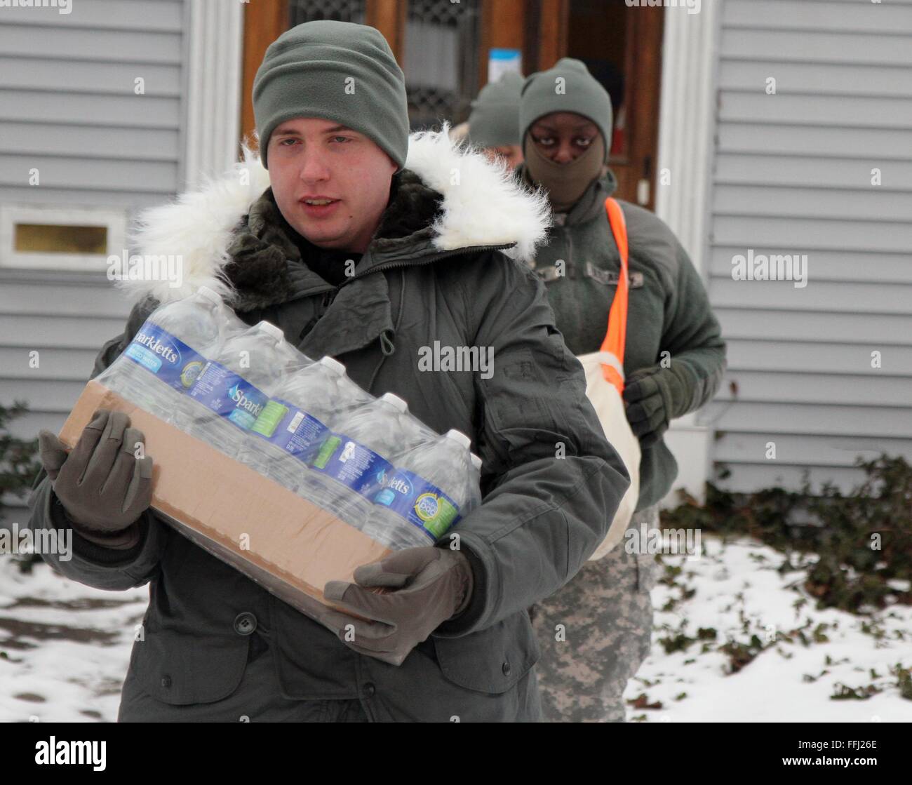 U.S Air Force airmen with the Michigan National Air Guard distribute bottled water to residents effected by lead contamination in the city drinking water January 23, 2016 in Flint, Michigan. As many as 12,000 children have been exposed to dangerous drinking water after the state government switched water supplies without complying with federal regulations on safety. Stock Photo