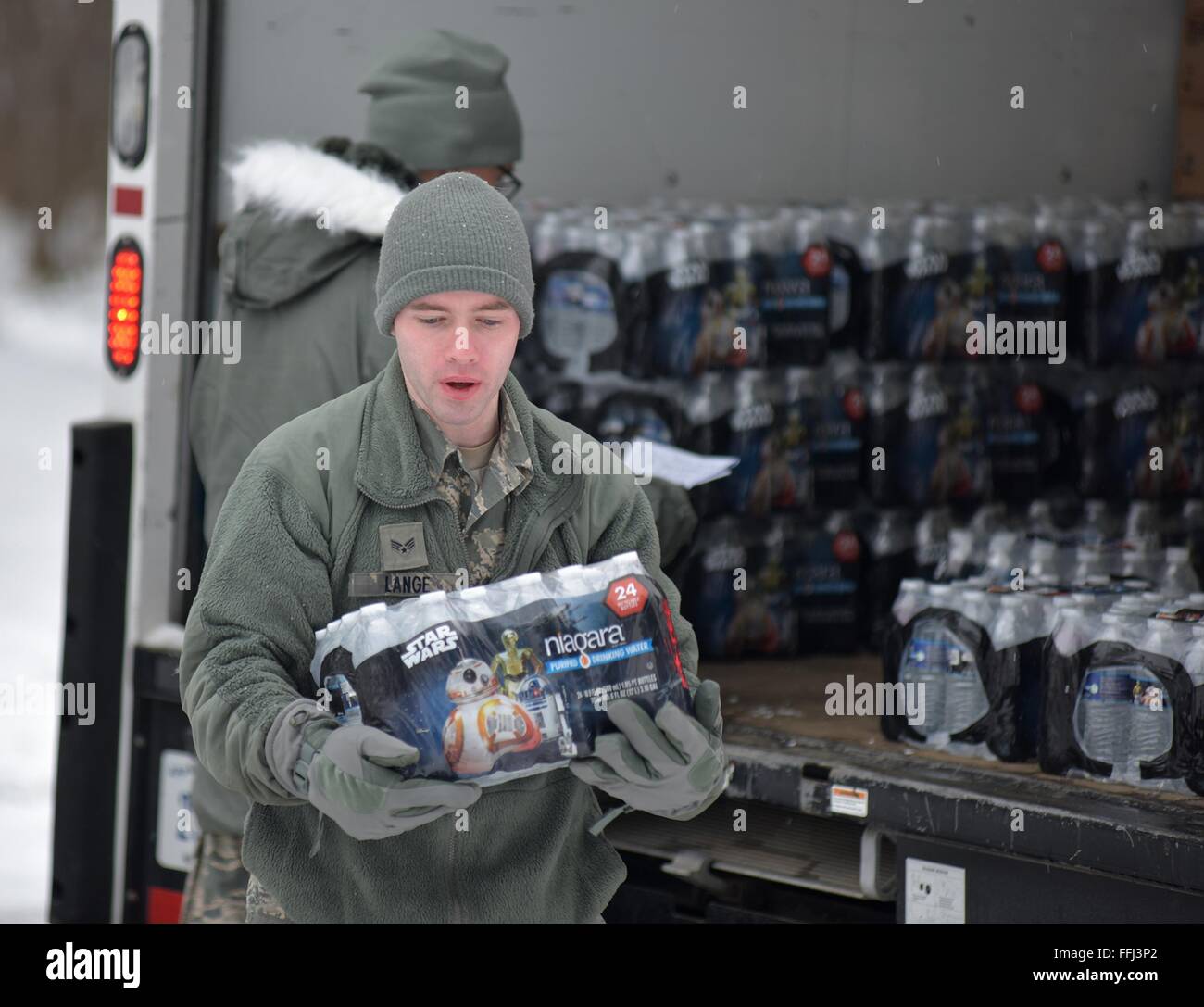 U.S Air Force airmen with the Michigan National Air Guard unload bottled water for distribution to residents effected by lead contamination in the city drinking water January 21, 2016 in Flint, Michigan. As many as 12,000 children have been exposed to dangerous drinking water after the state government switched water supplies without complying with federal regulations on safety. Stock Photo