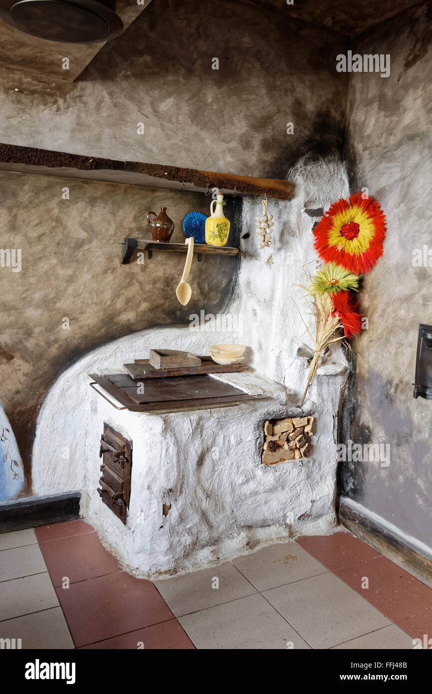 Old kitchen in a cottage with a wood fired stove and households Stock Photo