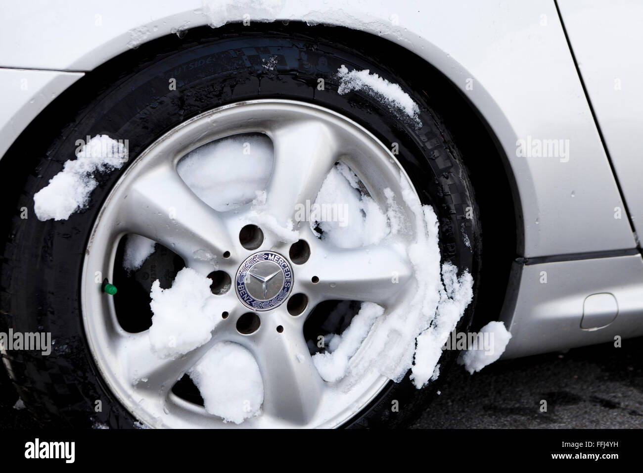 Car wheel covered in snow - Virginia USA Stock Photo