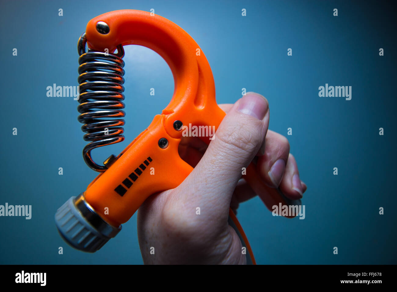 Hand Grip exercising with a spring loaded adjustable hand grip exerciser Stock Photo