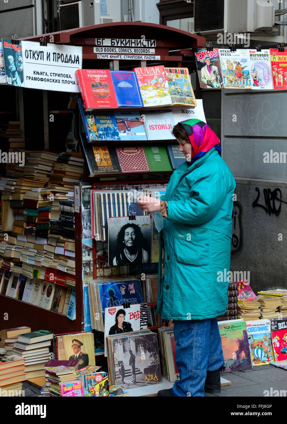 Serb woman attends to outdoor magazine books & vinyl records stall Belgrade Serbia Stock Photo