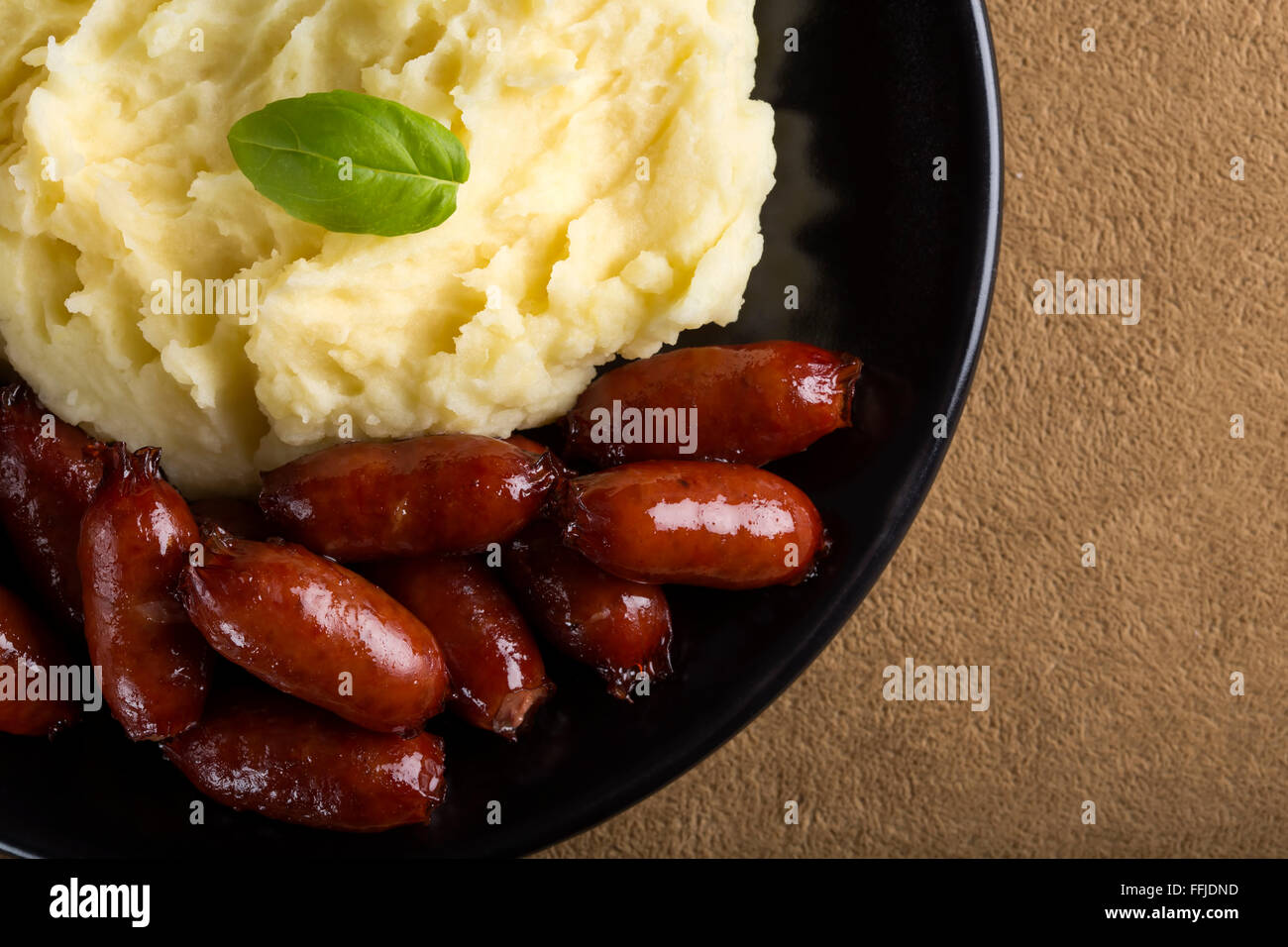 Sausage with mashed potatoes on dark plate Stock Photo