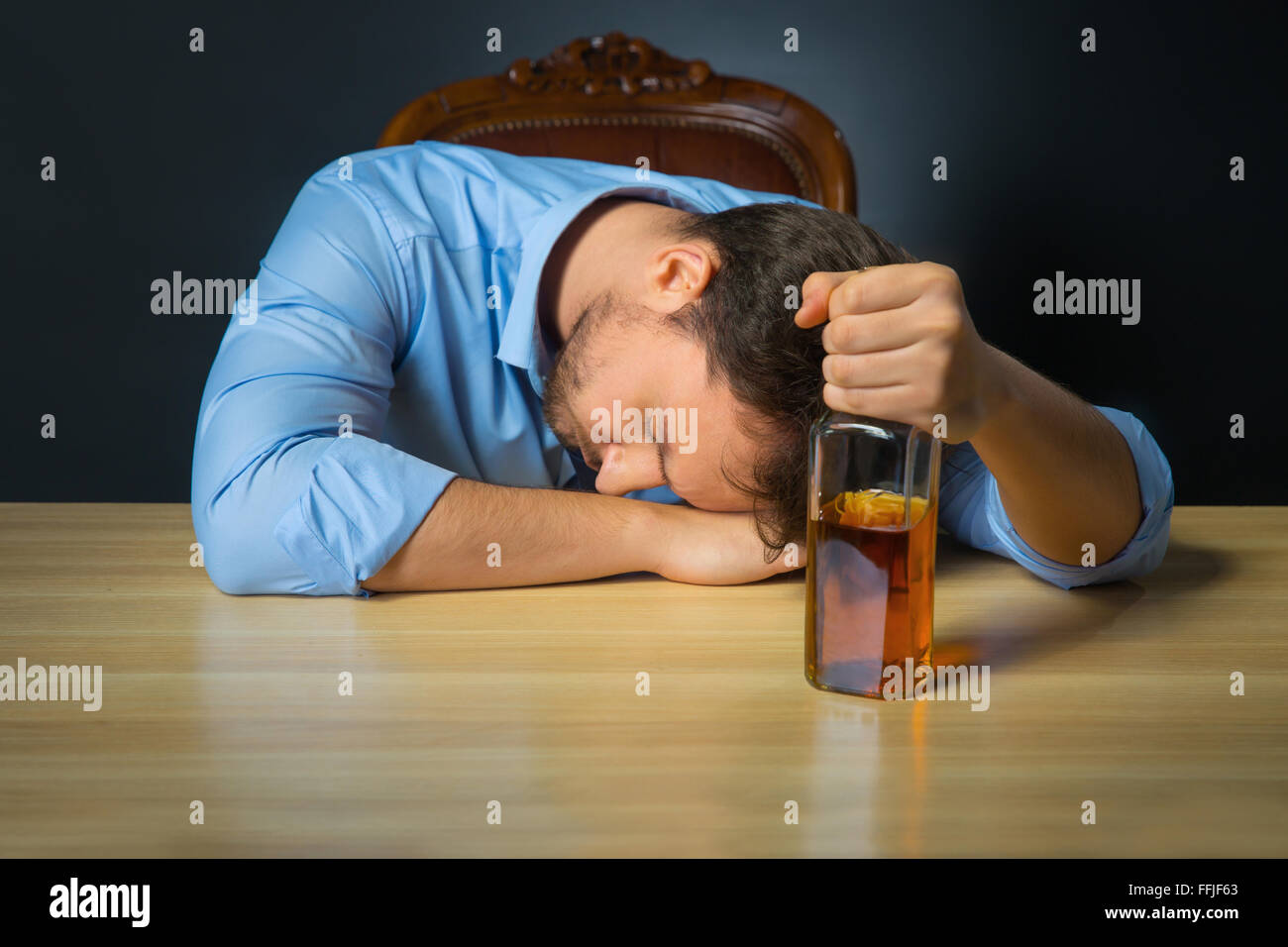 Drunk man drinking alcohol at the table Stock Photo