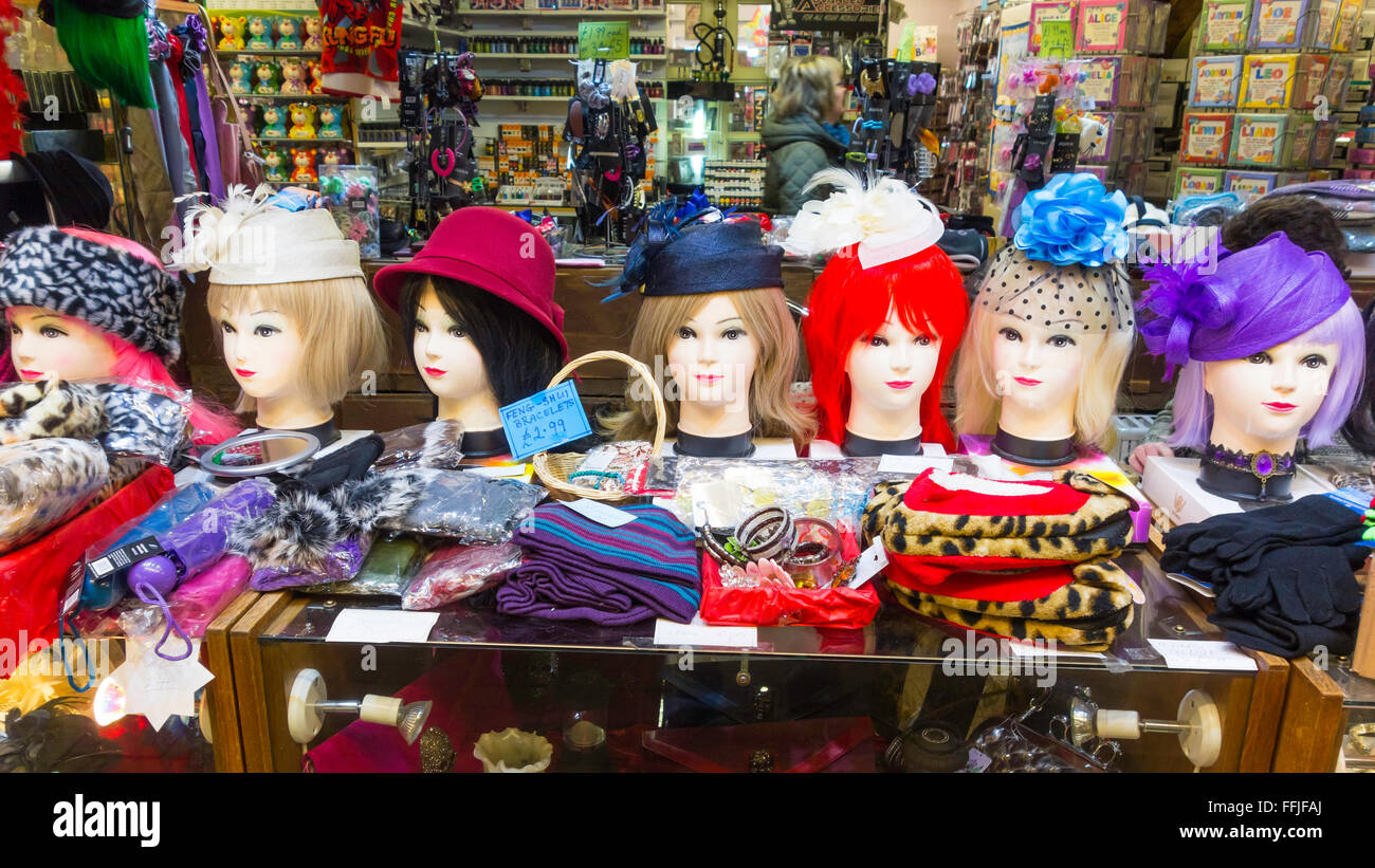 Seven Manikins heads displaying wigs and hats on an indoor market stall. Stock Photo