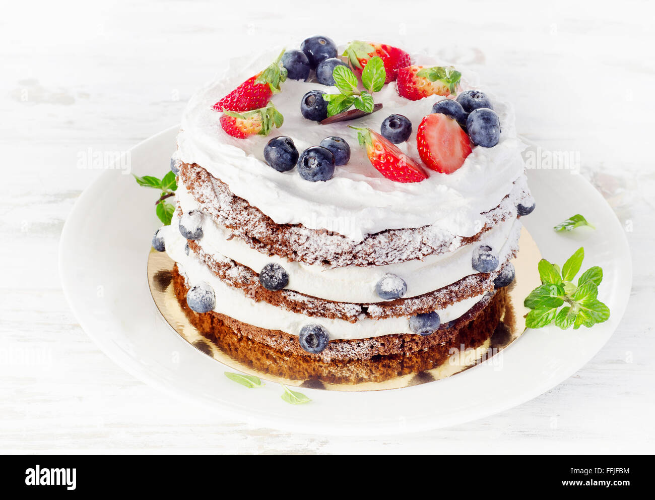 Cake with cream, fresh blueberries  and strawberries. Stock Photo