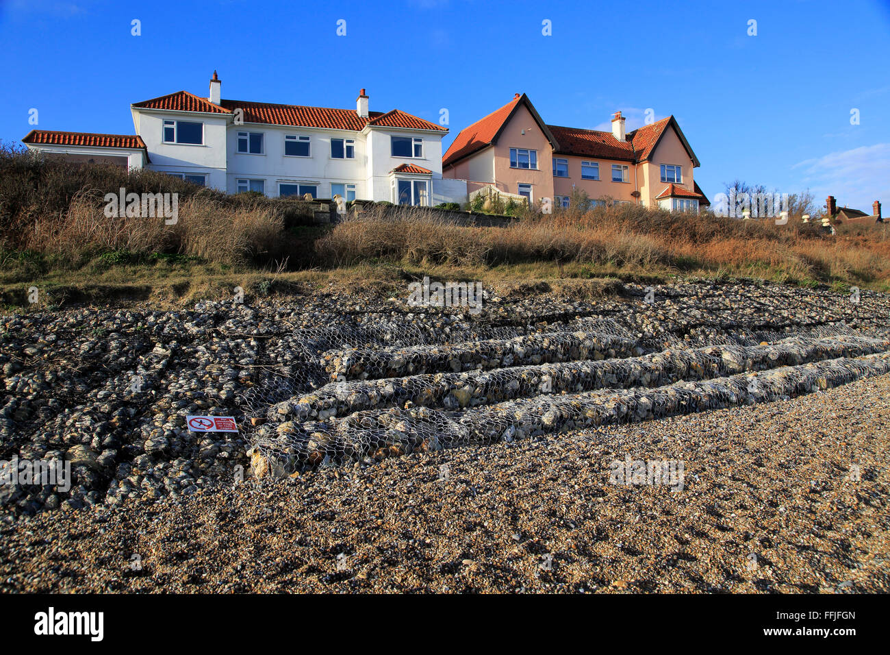 Gabion steel cages containing rocks form coastal defences at Stock