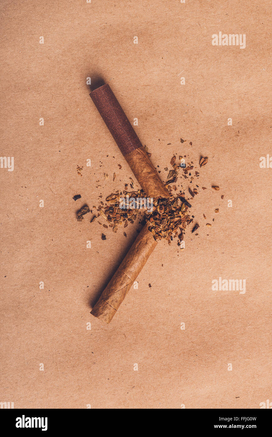 Broken cigarette top view over brown paper, quit smoking concept, warm