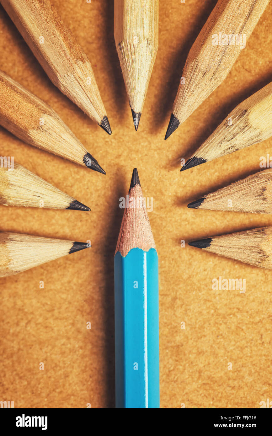 Contempt toward unique ones, being different, weird, surrounded by adversity, judging the odd one, wood pencils on desk Stock Photo