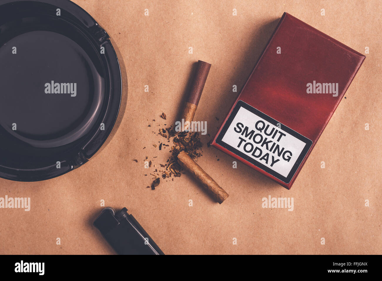 cigarettes smoked today Quit smoking today concept, top view, warm retro toned image of ashtray,  pack of cigarettes, a lighter and broken cigarette on t Stock Photo